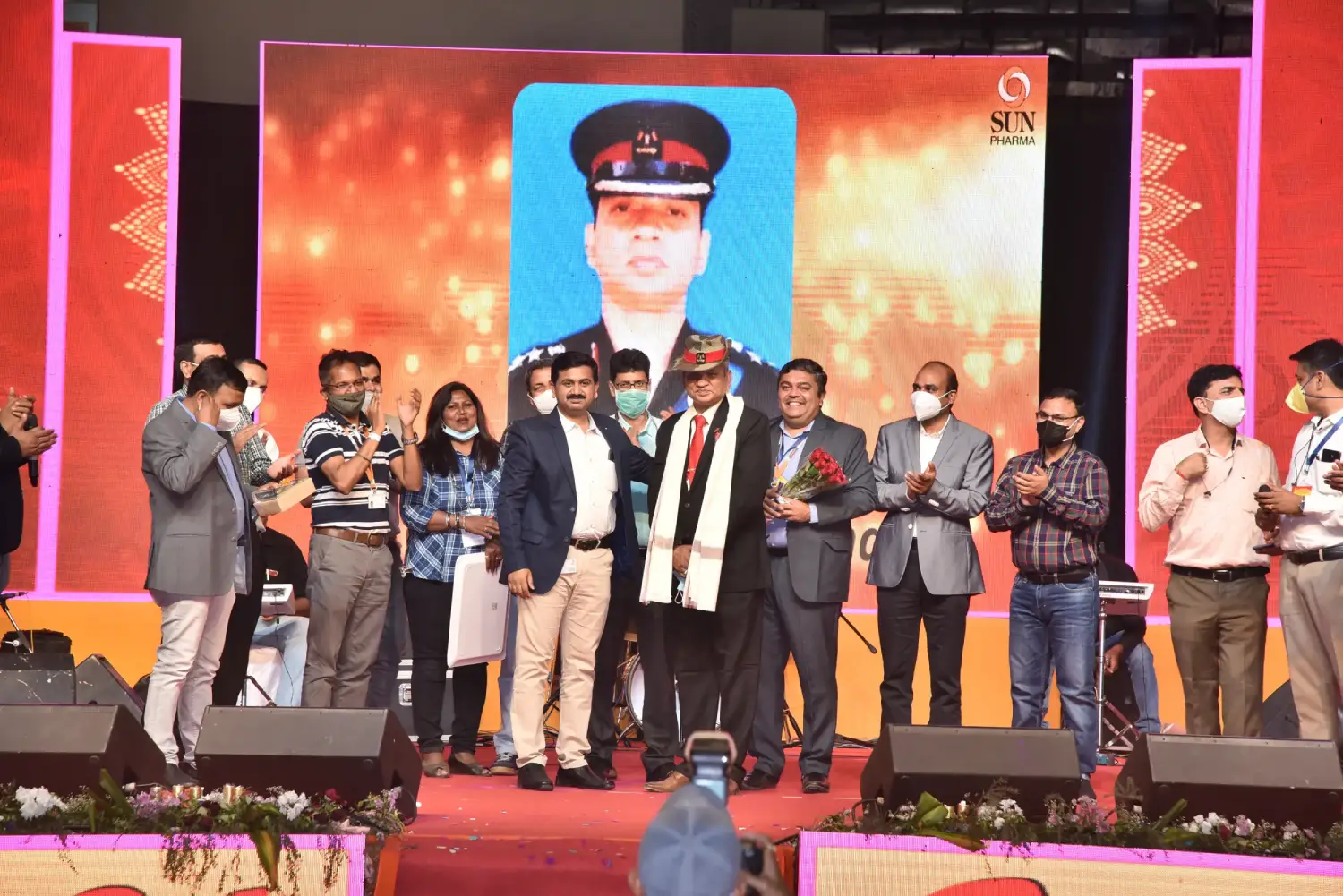 Man and woman speaking on stage at night with blue lighting